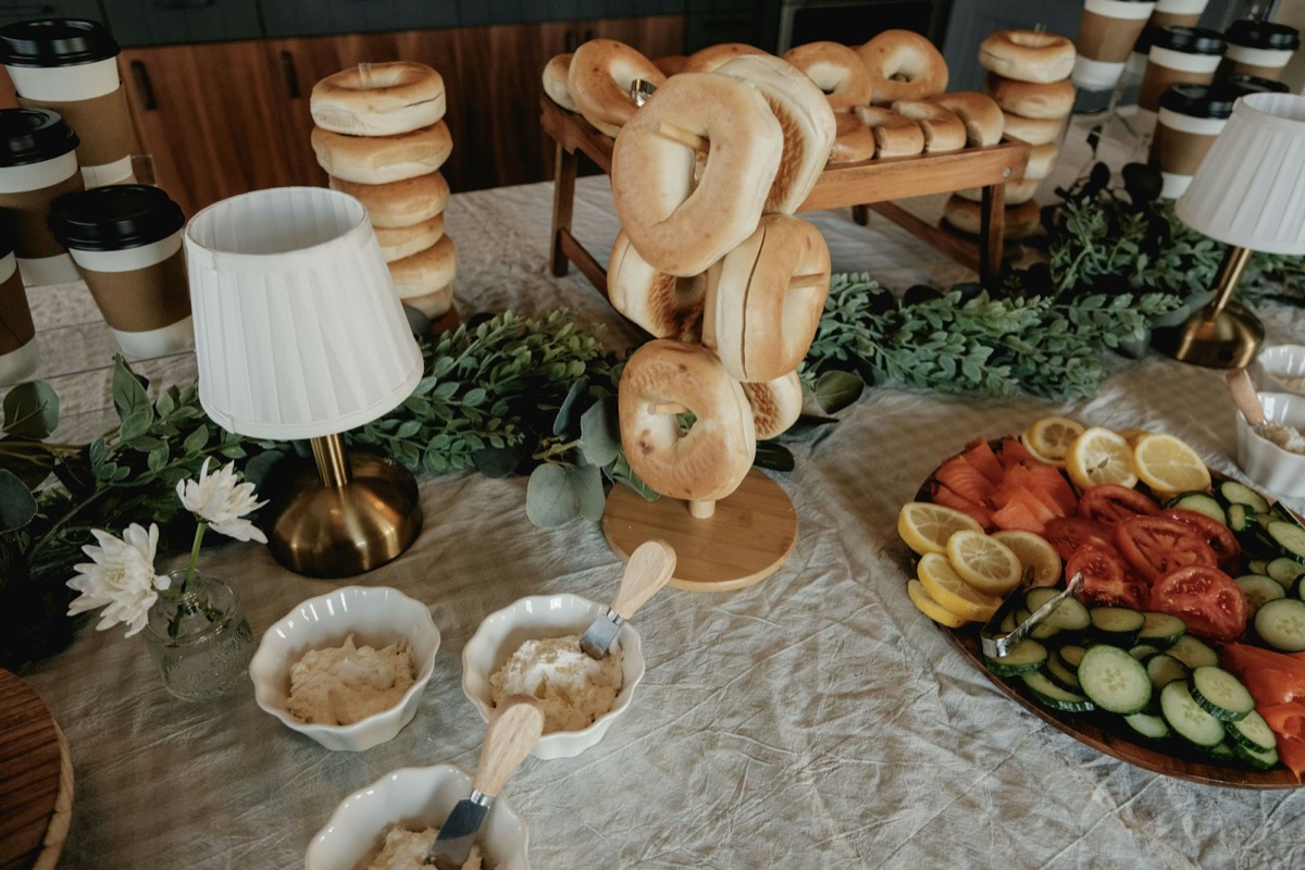 A brunch spread of bagels, cream cheese, fruit and vegetables